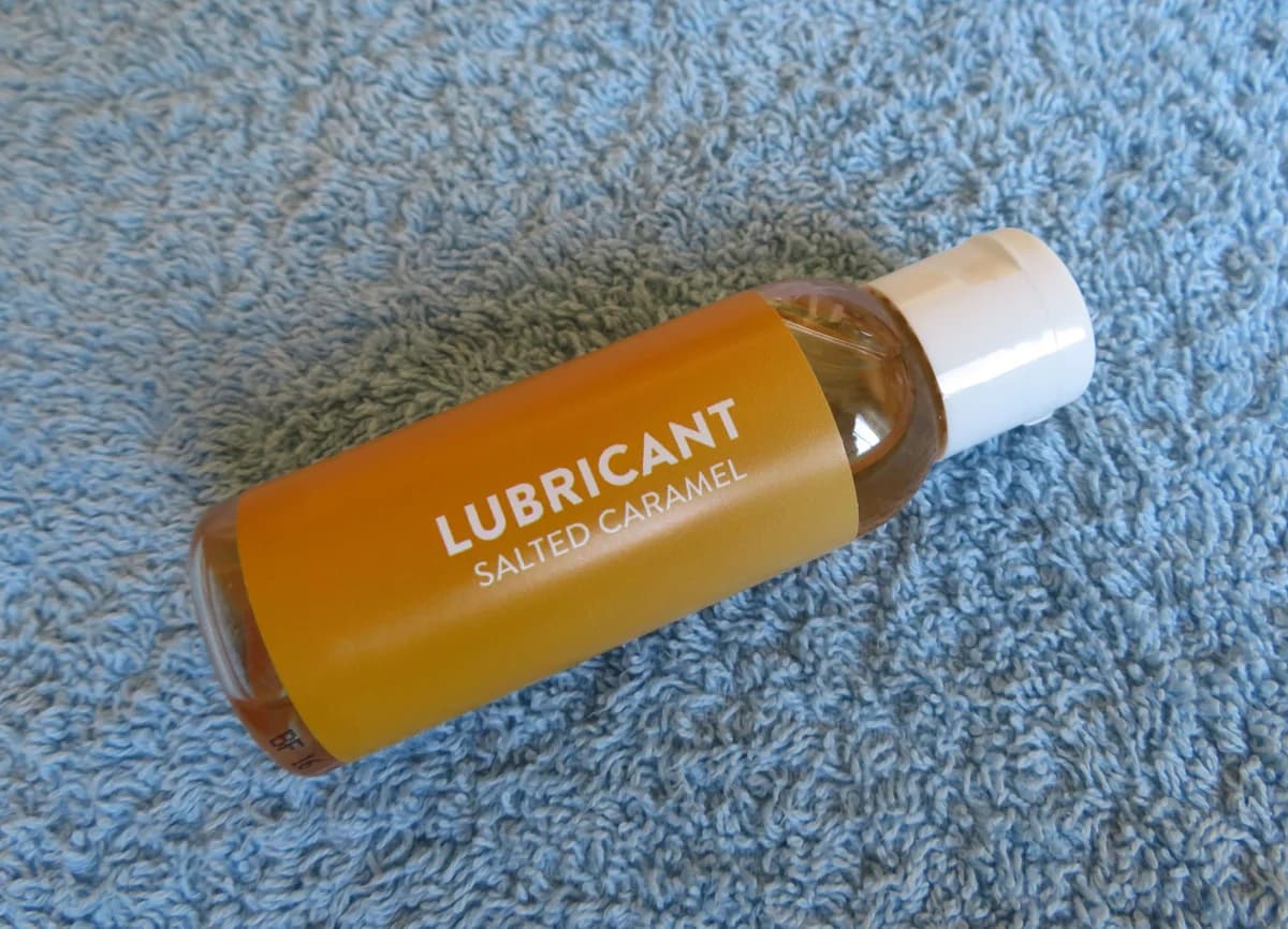 A personal lubricant bottle resting on a blue towel
