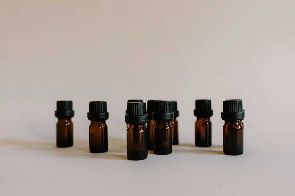 Unlabelled amber oil bottles arranged on a neutral background